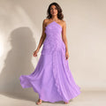 Modelo con vestido maxi halter morado de corpiño estructurado y falda asimétrica de volantes plisados en cascada