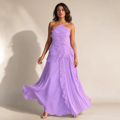 Modelo con vestido maxi halter morado de corpiño estructurado y falda asimétrica de volantes plisados en cascada