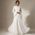 Modelo con vestido maxi blanco de volantes en corpiño y manga acampanada, falda que llega al suelo con vuelo amplio