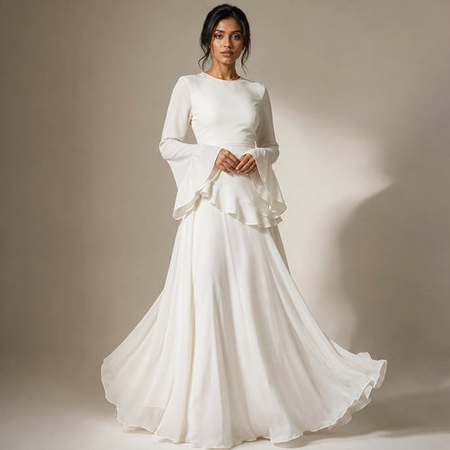 Modelo con vestido maxi blanco de volantes en corpiño y manga acampanada, falda que llega al suelo con vuelo amplio