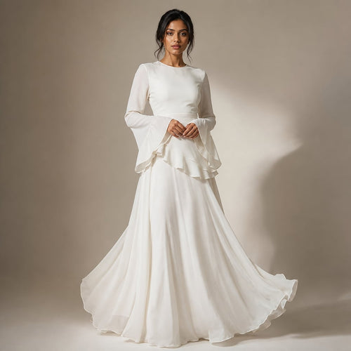 Modelo con vestido maxi blanco de volantes en corpiño y manga acampanada, falda que llega al suelo con vuelo amplio