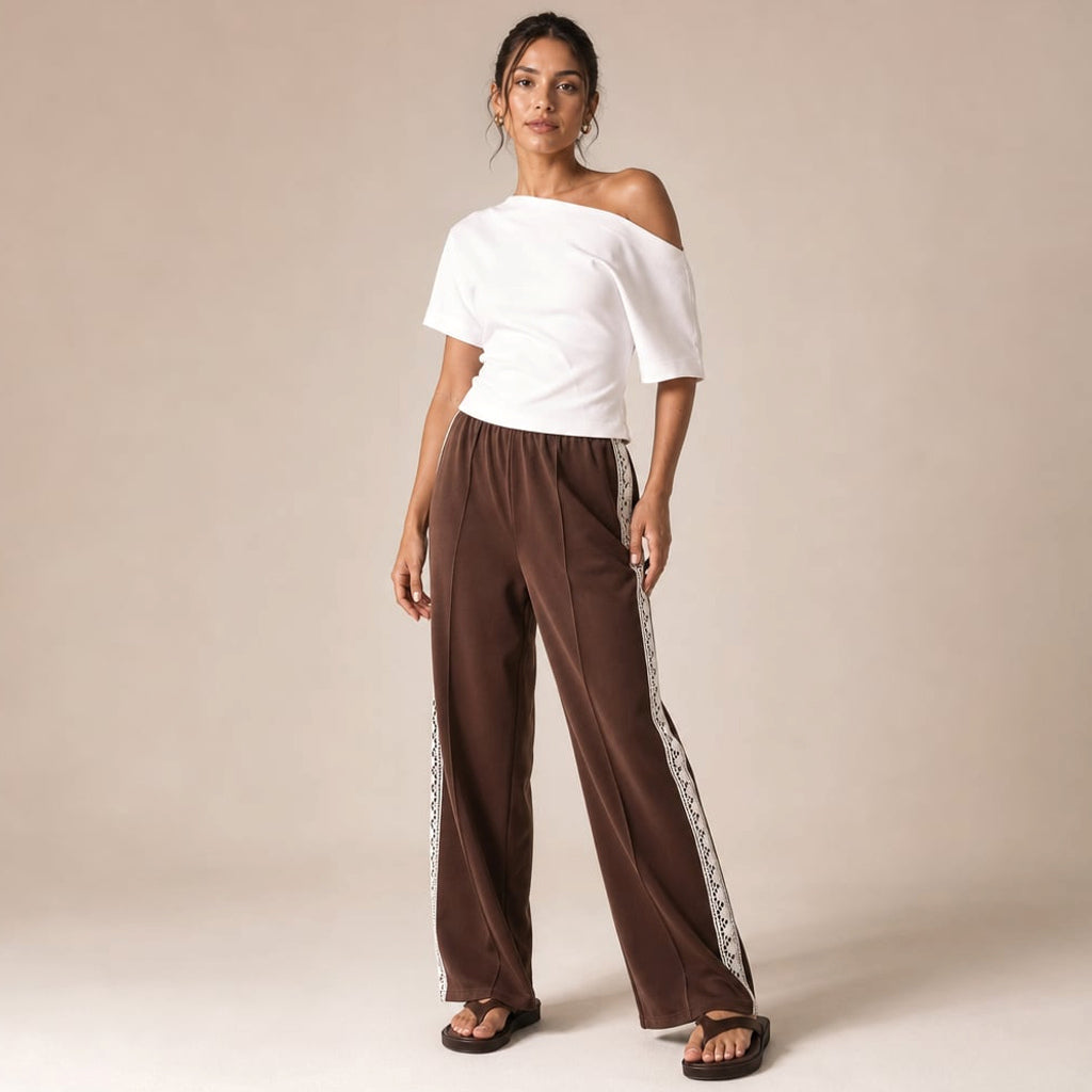 Pantalón recto plisado color chocolate con franja lateral y remate de encaje en el tobillo, vista frontal completa