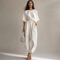 Modelo con conjunto de lino blanco blusa drapeada y pantalón pierna ancha tiro alto
