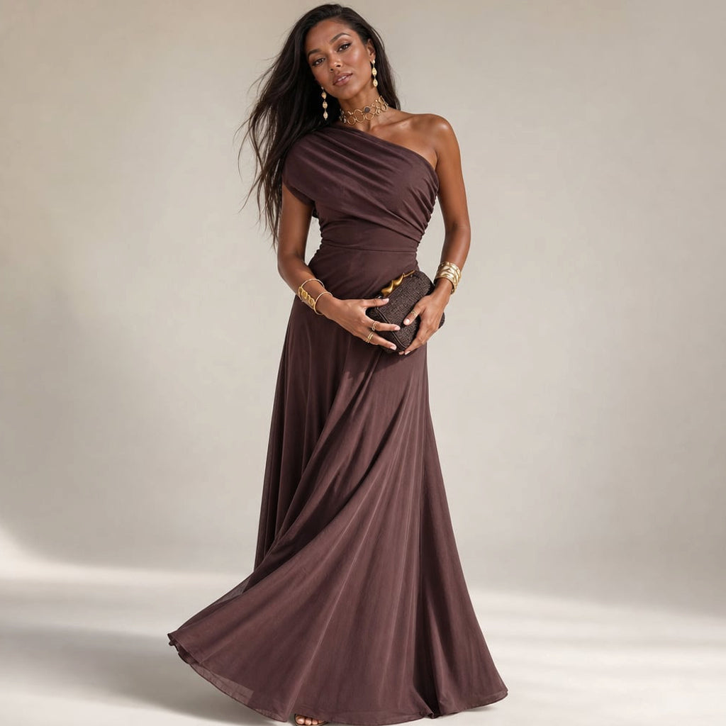 Modelo con vestido maxi plisado café de hombro asimétrico, silueta completa