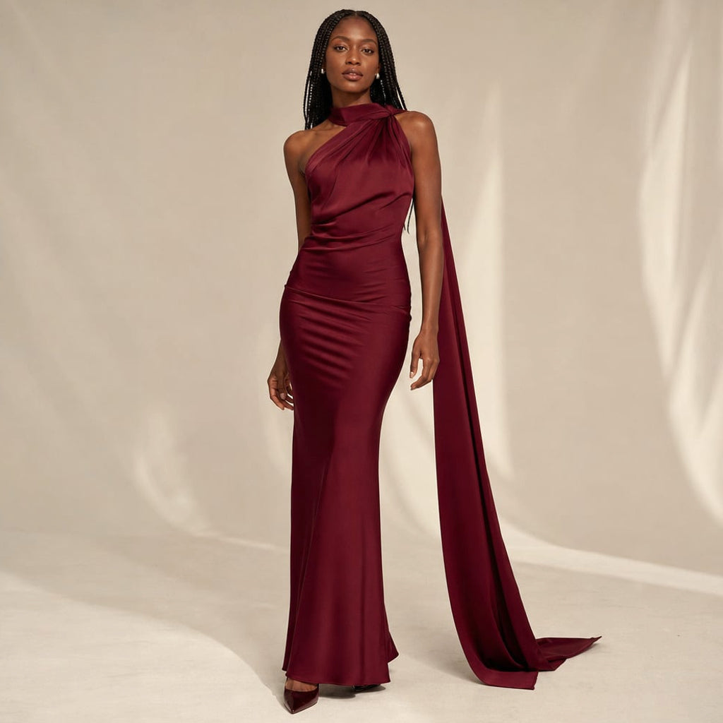 Modelo con vestido maxi drapeado vino, tirante cruzado en clavícula y dobladillo al ras del piso