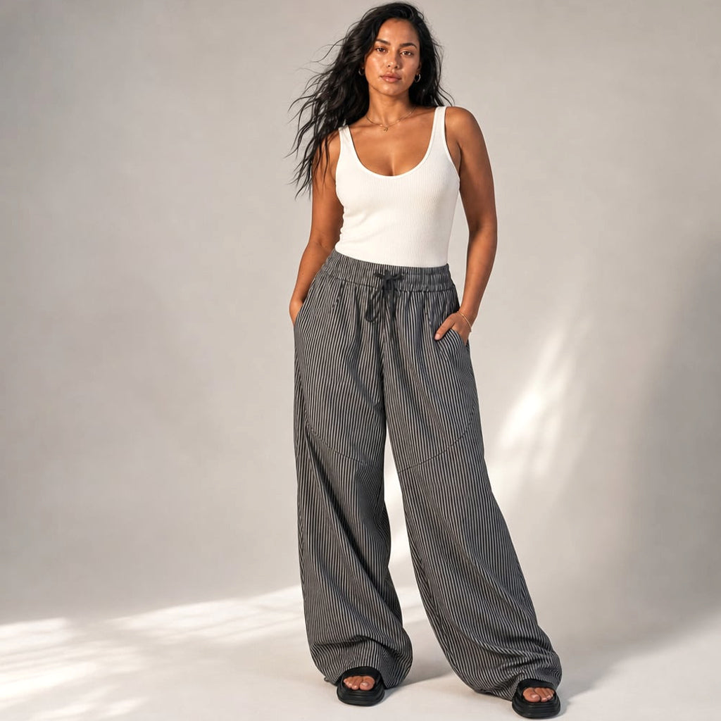 Modelo lleva pantalón barrel leg gris con pierna redondeada y pretina elástica, tiro alto, talla S