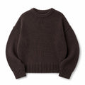 Modelo con jumper de punto chocolate, tejido cepillado y silueta relajada, combinado con pantalón de pinzas
