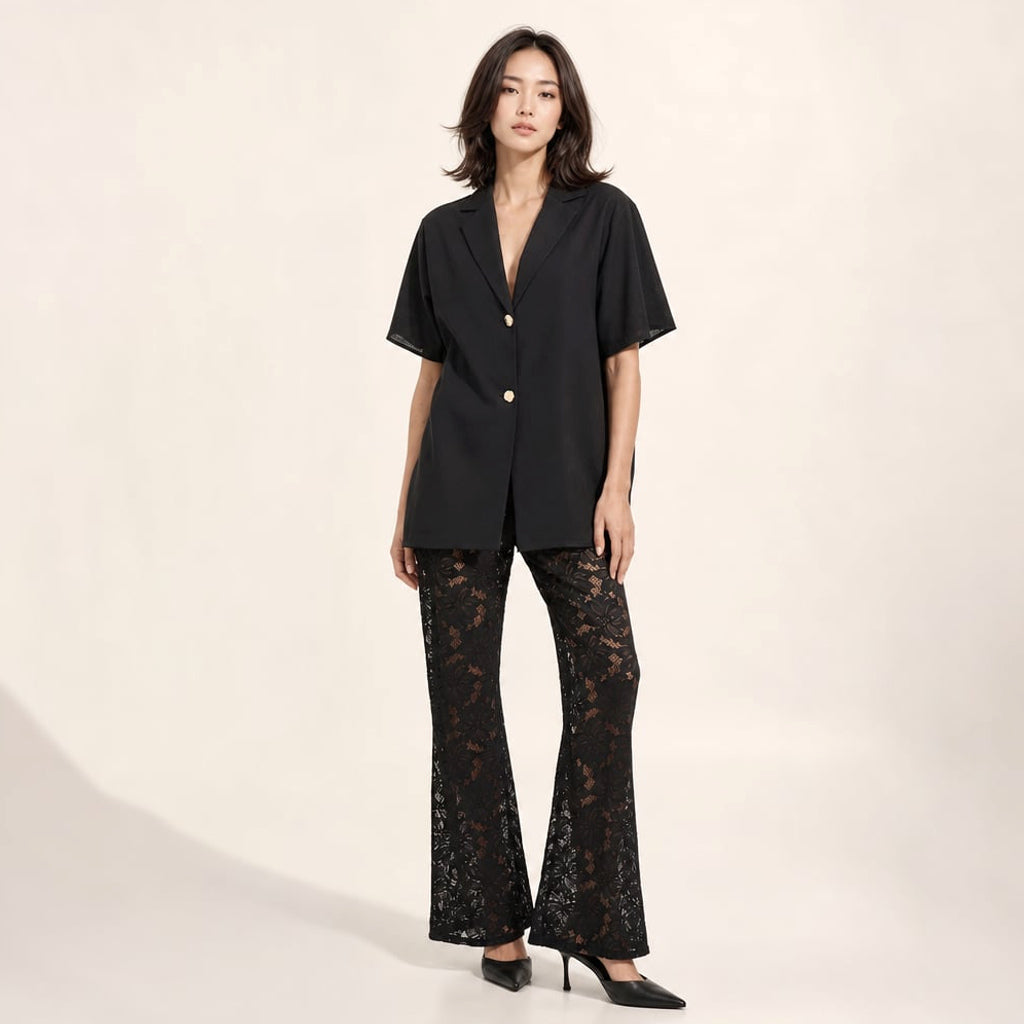 Conjunto dos piezas negro: blusa de algodón manga corta con botón dorado y pantalón de encaje transparente pierna ancha, vista frontal completa