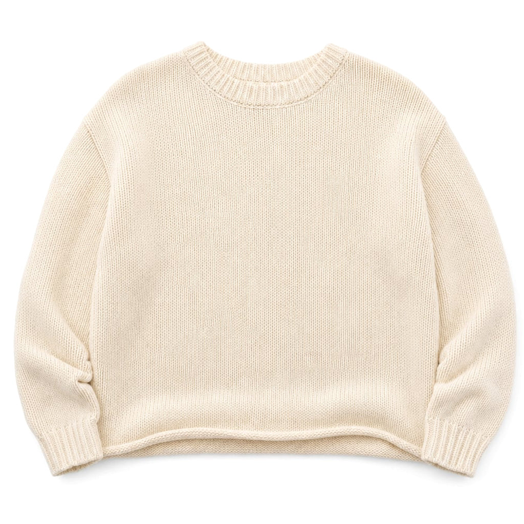 Modelo usando suéter de punto crema con cuello redondo y manga larga, look casual estructurado