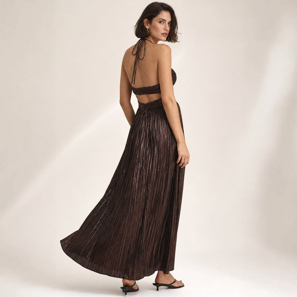 Modelo de pie con vestido maxi halter chocolate, hombros descubiertos y cut-out estructural en el corpiño, largo hasta el piso
