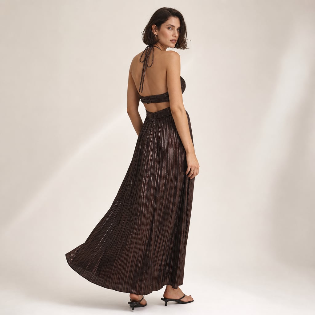 Modelo de pie con vestido maxi halter chocolate, hombros descubiertos y cut-out estructural en el corpiño, largo hasta el piso