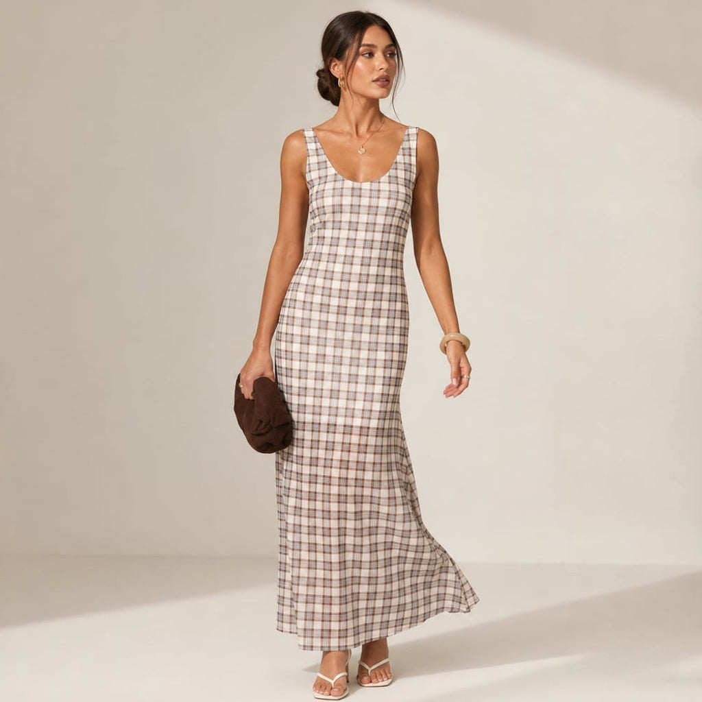 Modelo de frente con vestido maxi cuadros neutros, overlay que cae con movimiento, escote redondo y tirantes fijos